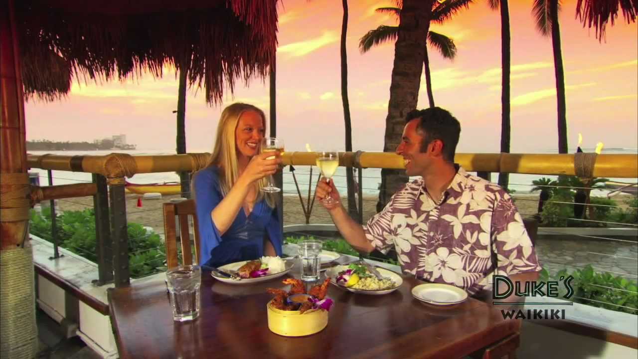Romantic Getaways in Hawaii a man and a woman sitting at a table eating and drinking wine