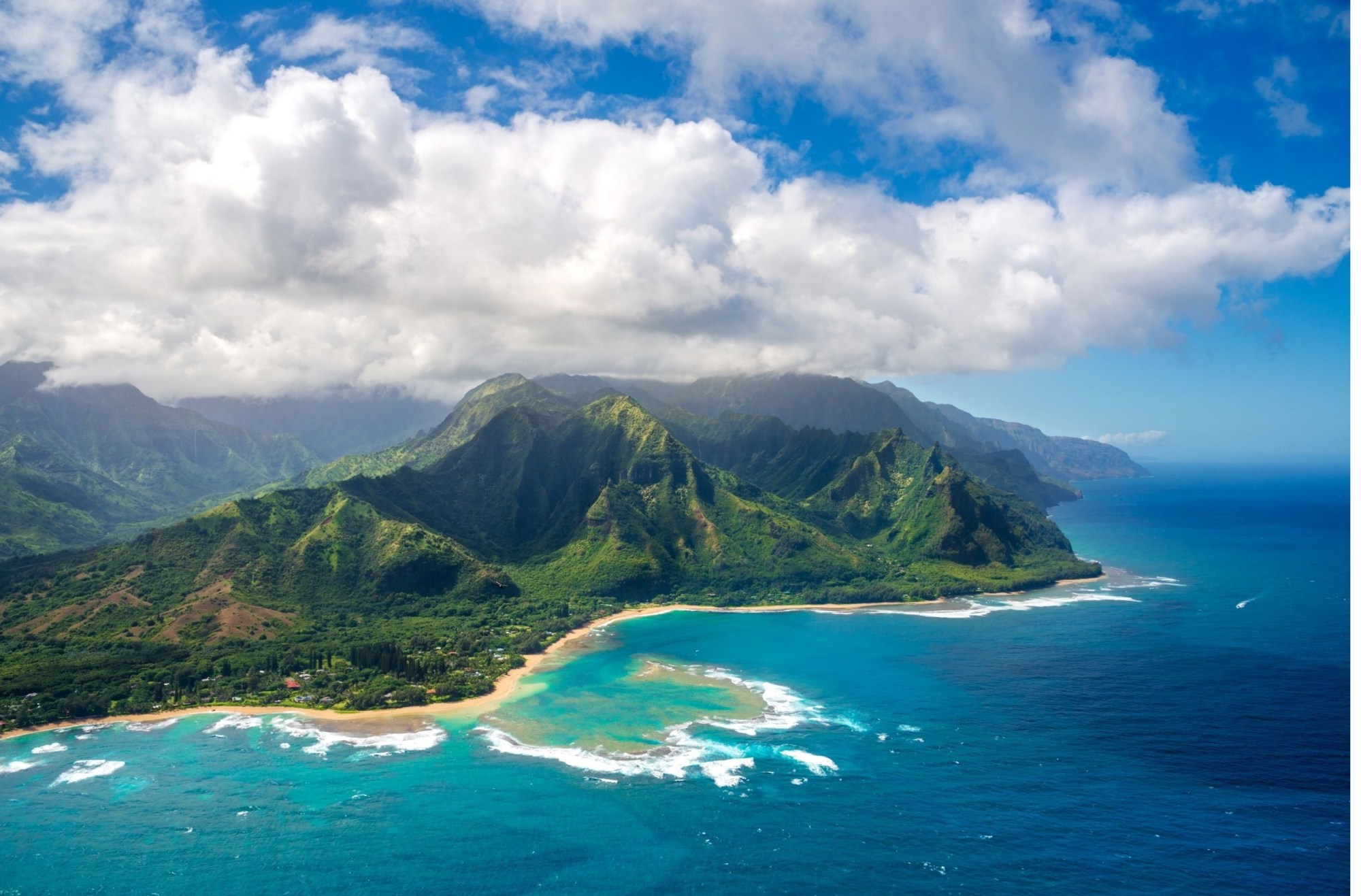 Nāpali Coast, Kauai a body of water with a mountain in the background
