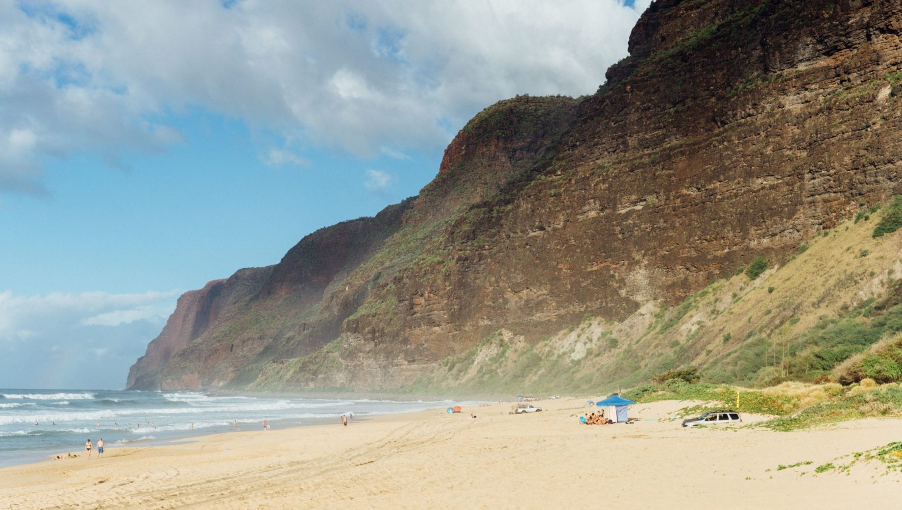 a beach with Polihale State Park in the background