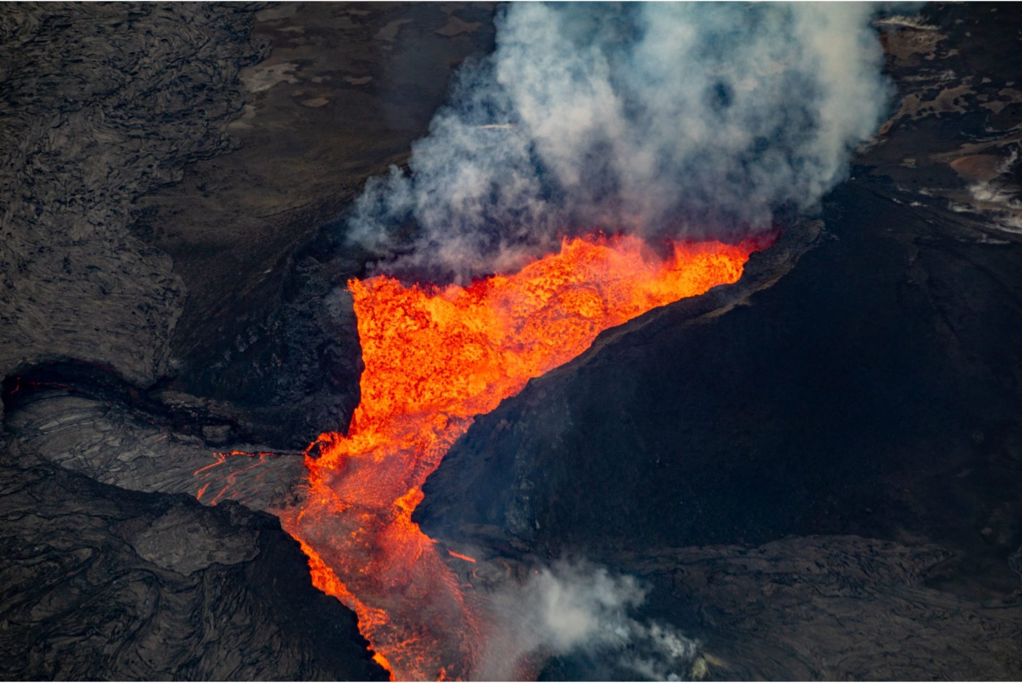 Kilauea eruption a fire pit with smoke coming out of it