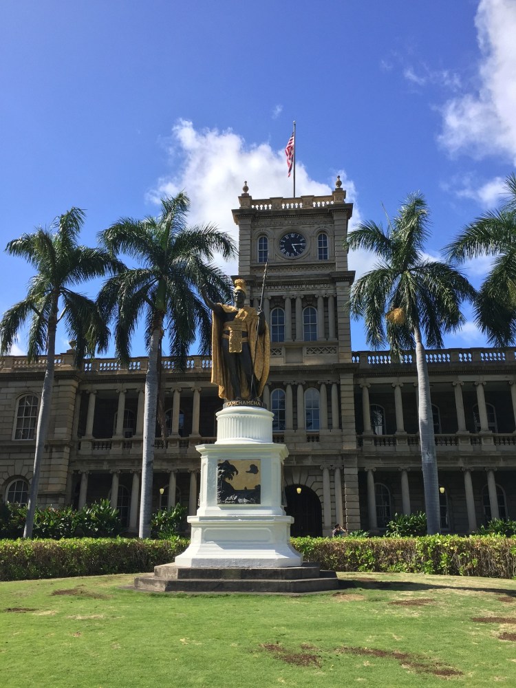 a large clock tower in front of Iolani Palace