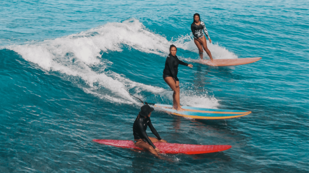 a young girl riding a wave on a surfboard in the ocean