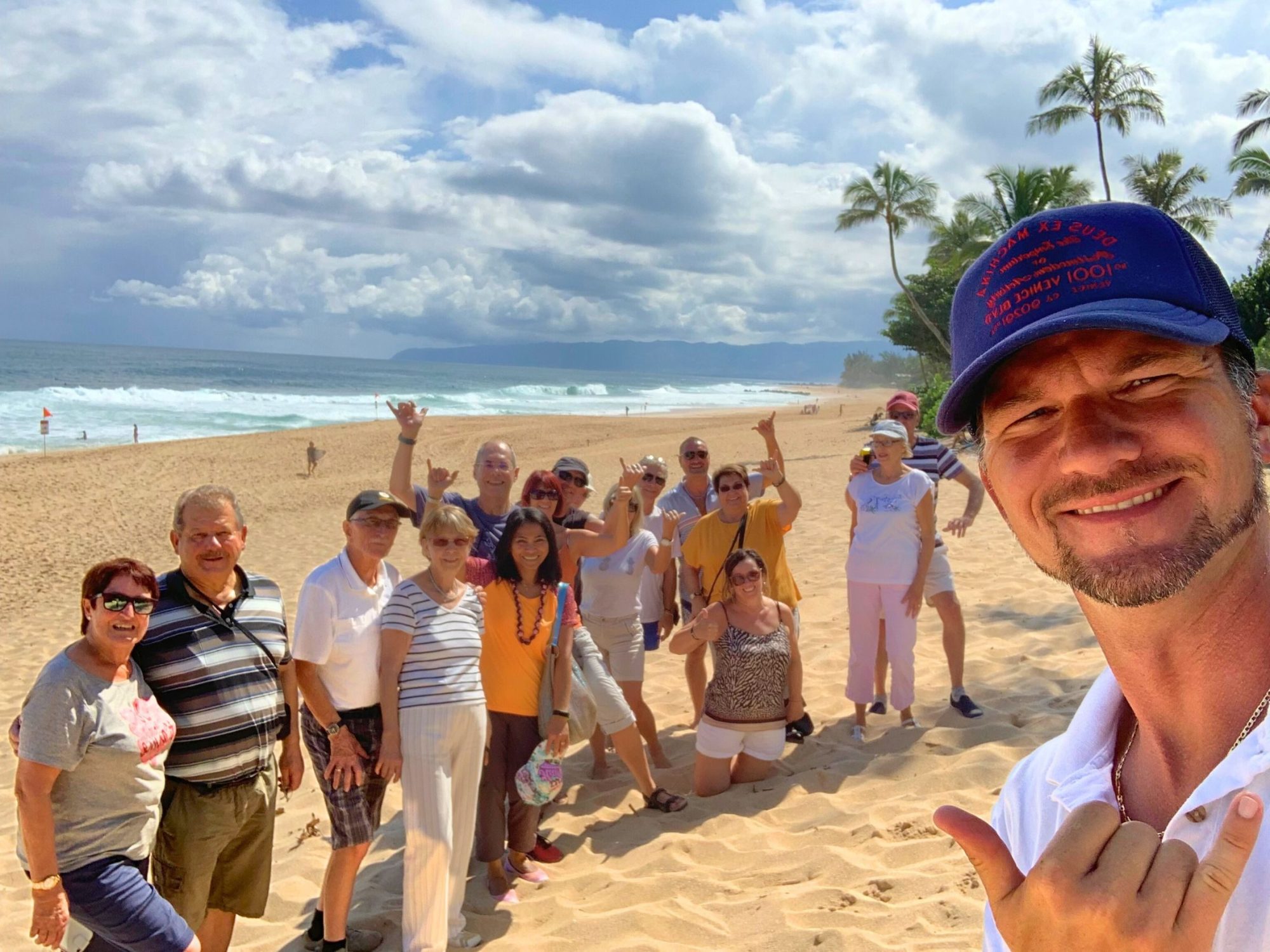 Oahu Group Tour Beach Guide a group of people standing on top of a sandy beach