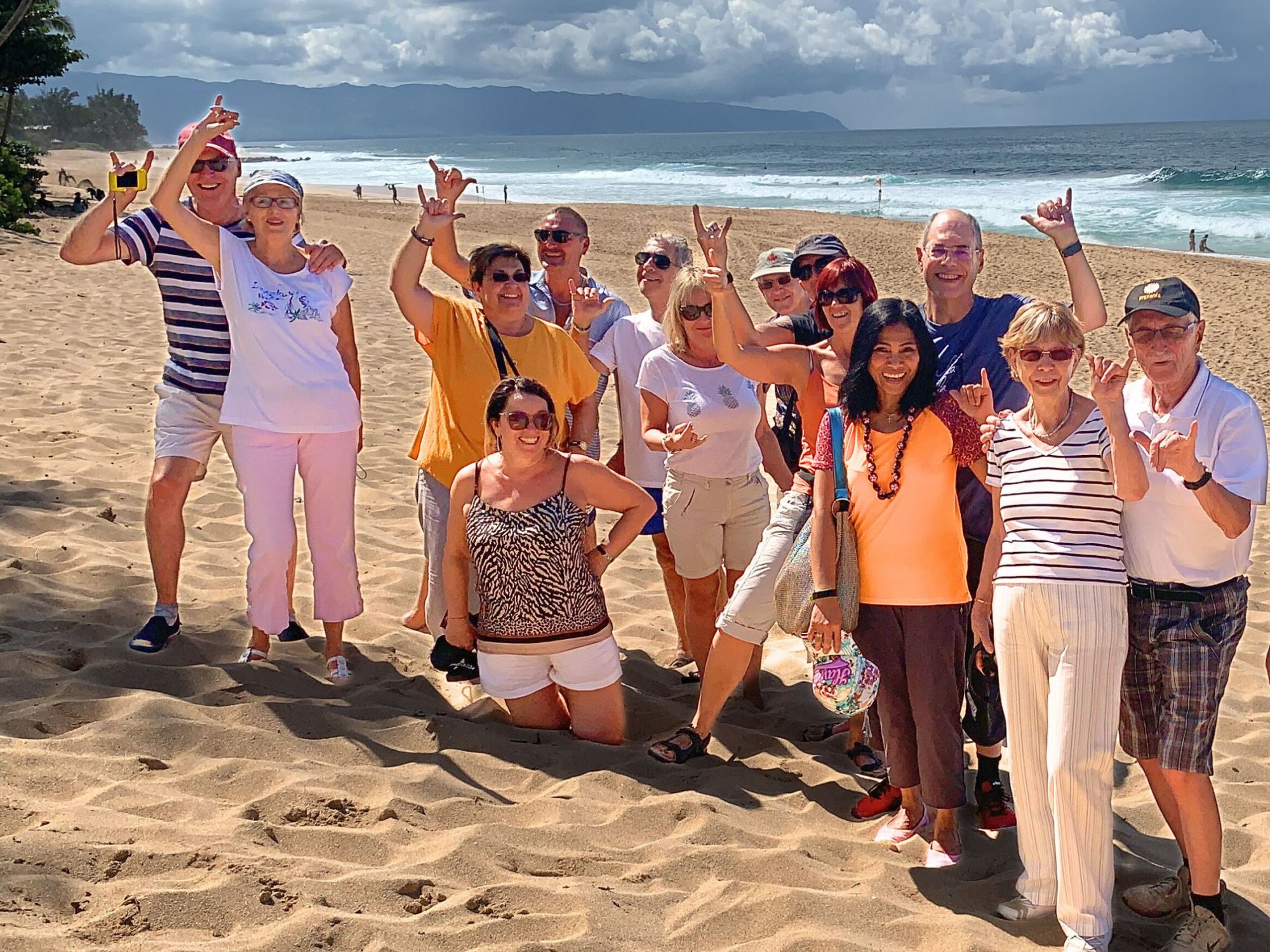 Oahu Group Tour Beach a group of people standing on top of a sandy beach