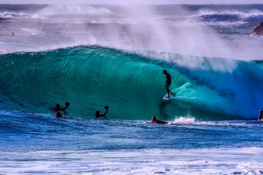 a group of people riding on top of a wave
