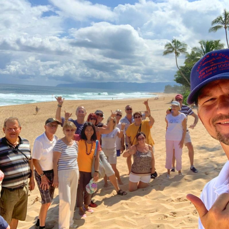a group of people standing on top of a sandy beach