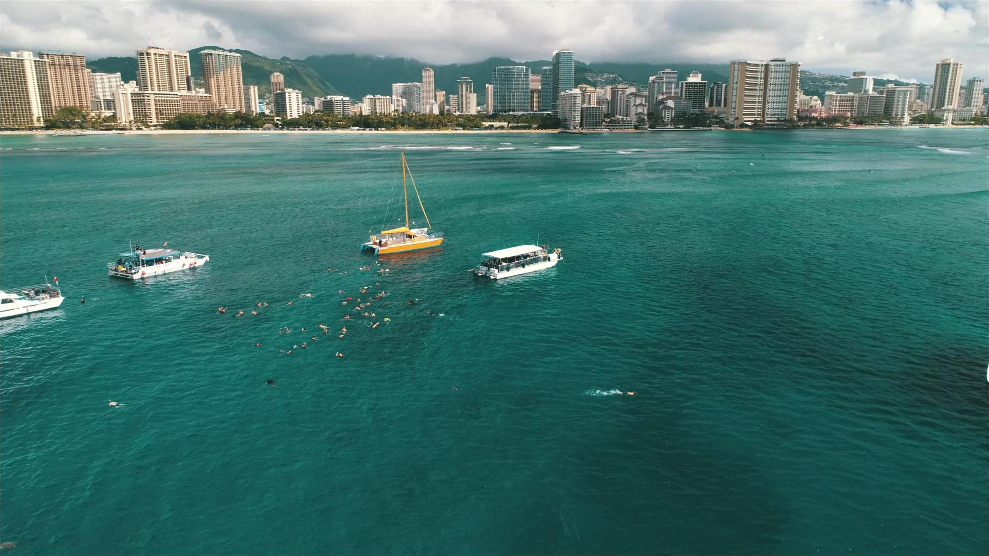2 Hour Turtle Snorkeling & Ocean Sports – 30% OFF Re Opening Sale Image 4 a small boat in a body of water with a city in the background