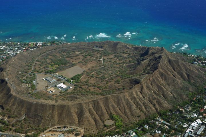 Aerial view of Diamond Head crater near Waikiki Beach with ocean in background.