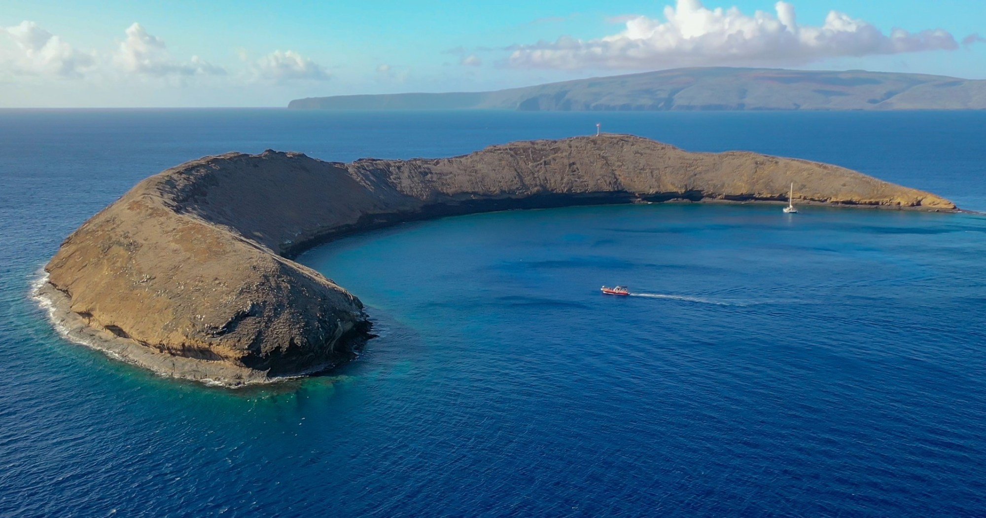 4-Hour Molokini plus Turtle Town Snorkel Trip on a 40-ft Raft Boat Image 1 an island in the middle of a body of water