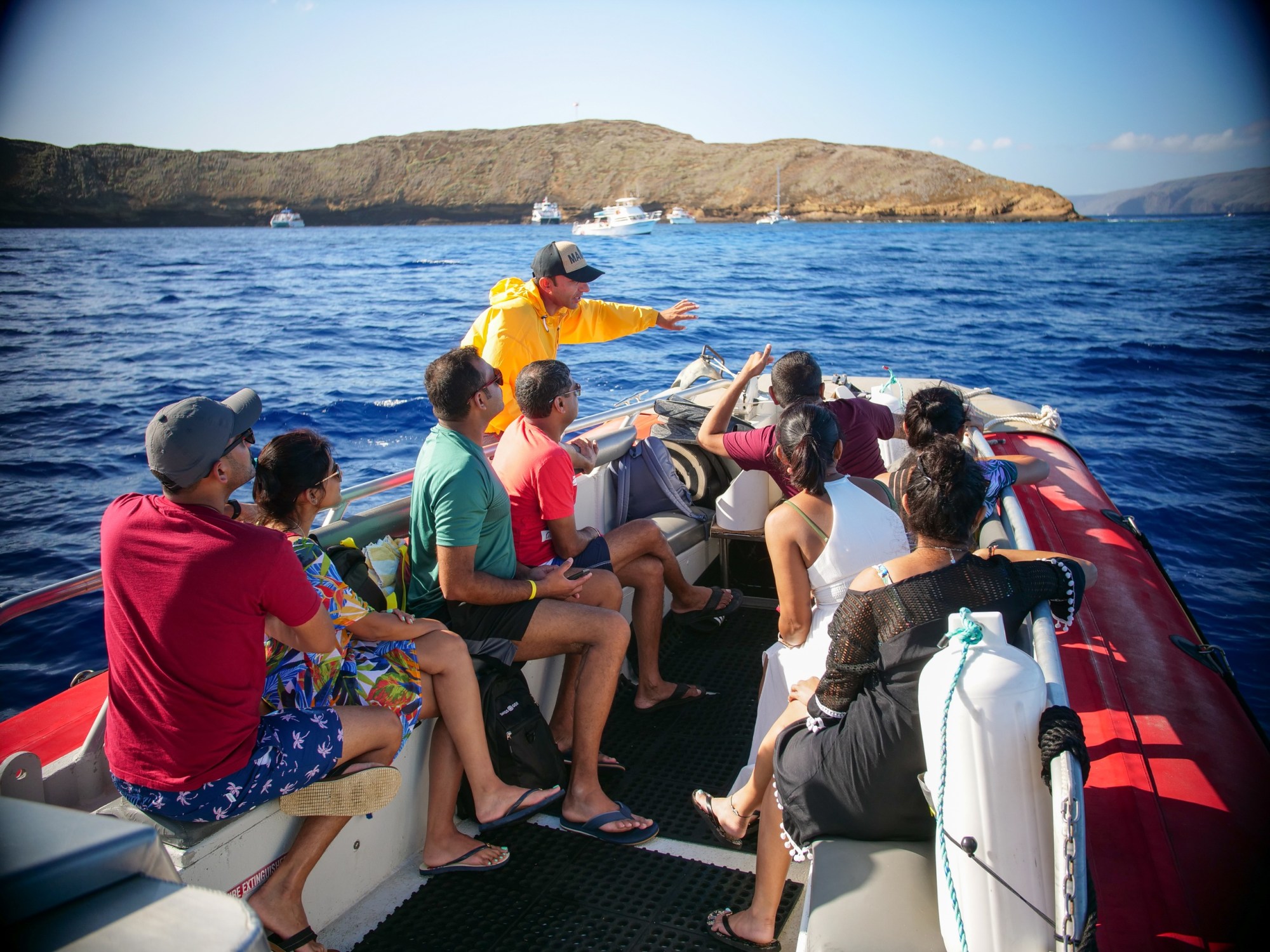 4-Hour Molokini plus Turtle Town Snorkel Trip on a 40-ft Raft Boat Image 6 a group of people standing next to a body of water