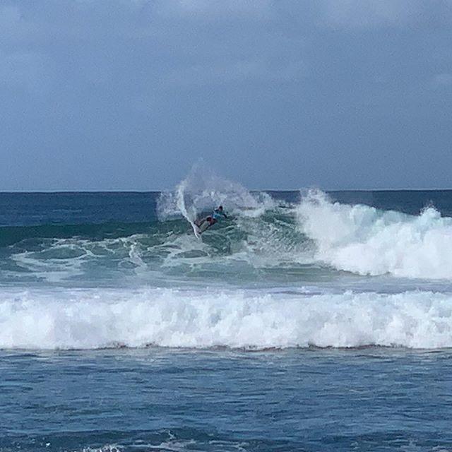a man riding a wave on a surfboard in the ocean with Southern Ocean in the background