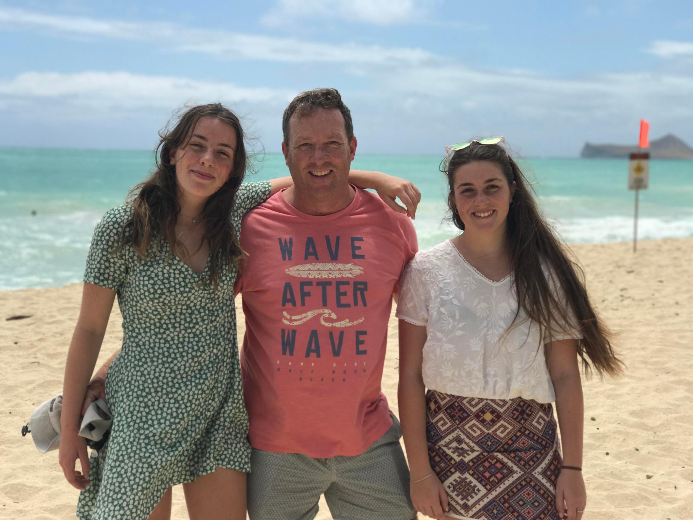 a woman standing next to a body of water posing for the camera