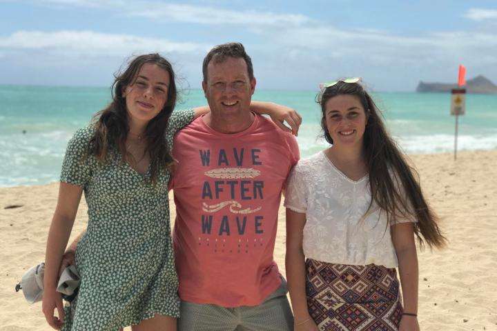 a woman standing next to a body of water posing for the camera