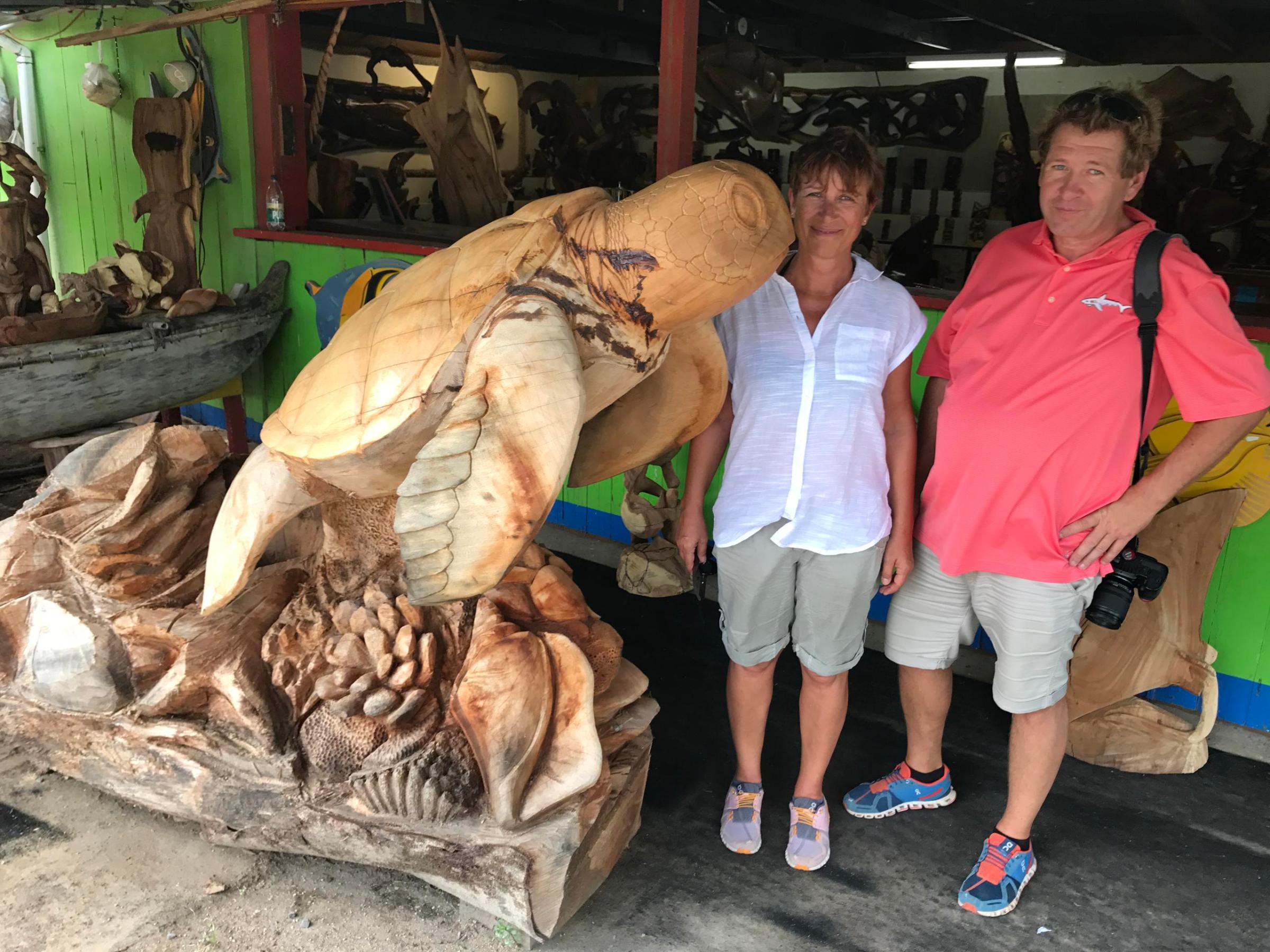 a group of people standing next to a stuffed animal