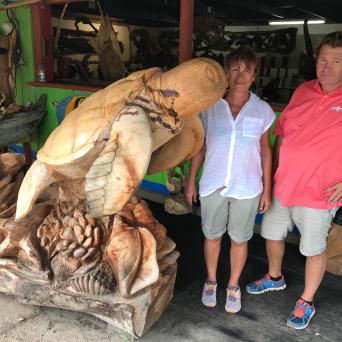 a group of people standing next to a stuffed animal