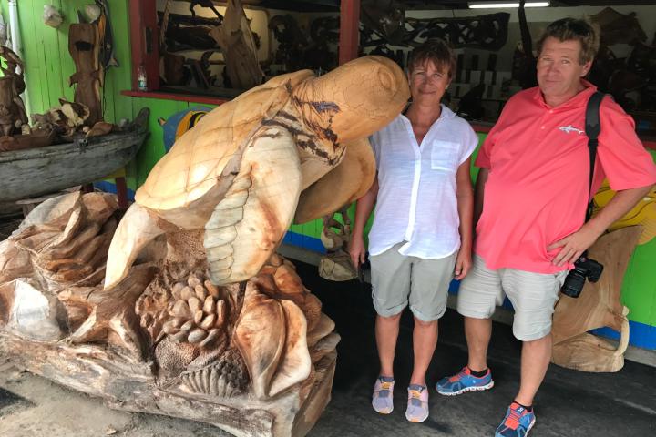 a group of people standing next to a stuffed animal