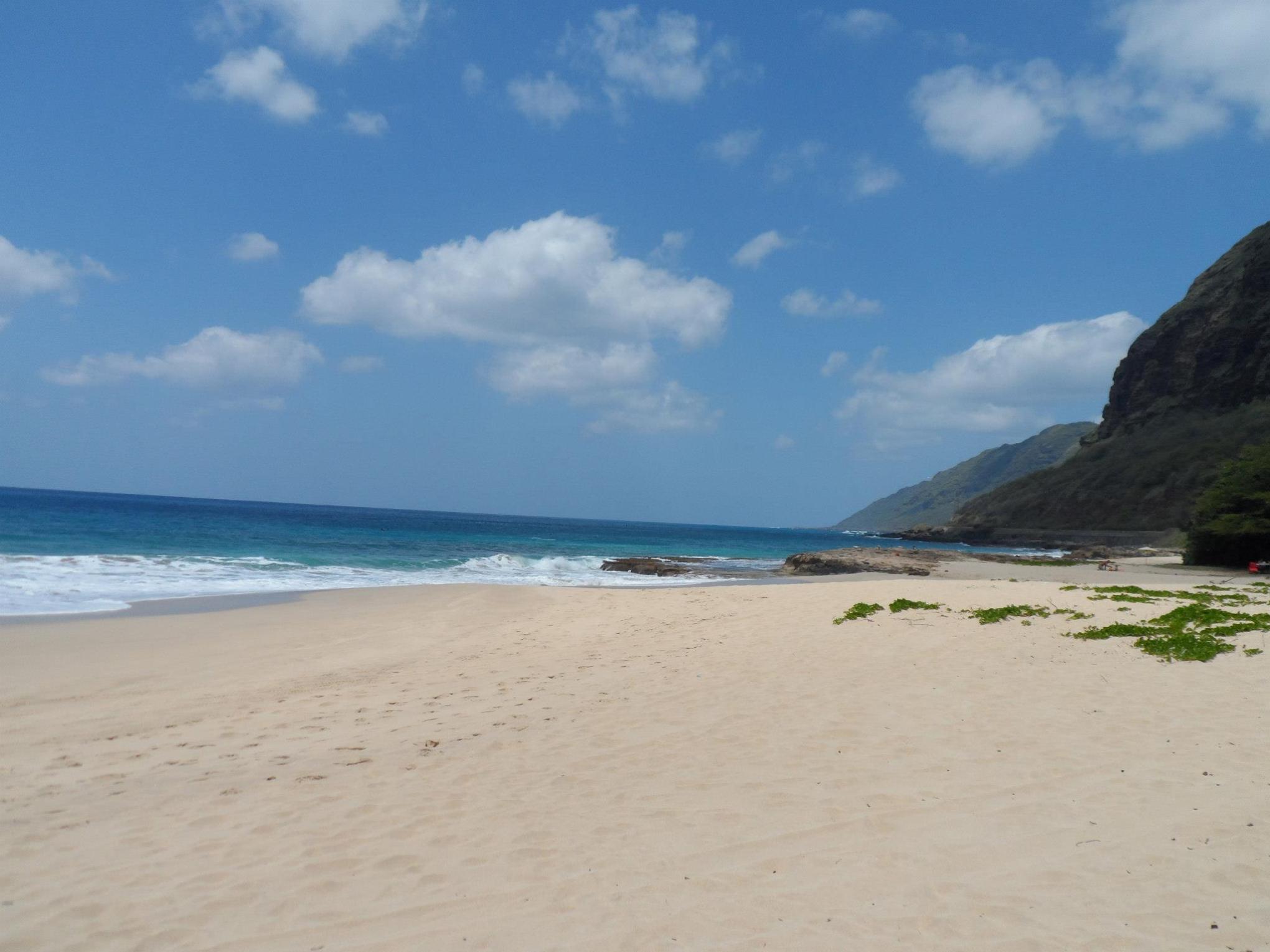 a sandy beach next to a body of water
