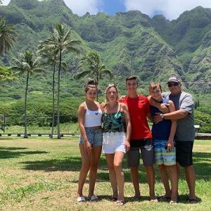 a group of people standing in front of a mountain