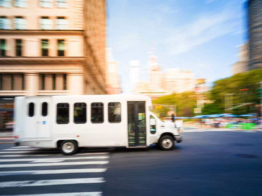 Private Airport to Hotel Shuttle Image 1 a bus driving down a city street