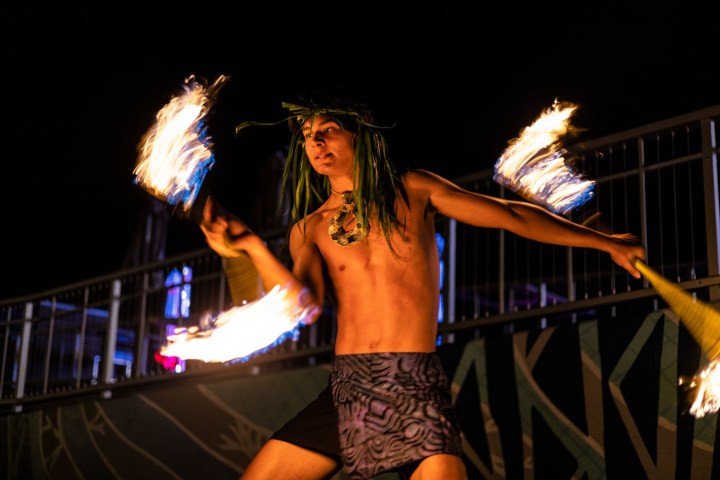 a man standing next to a fire