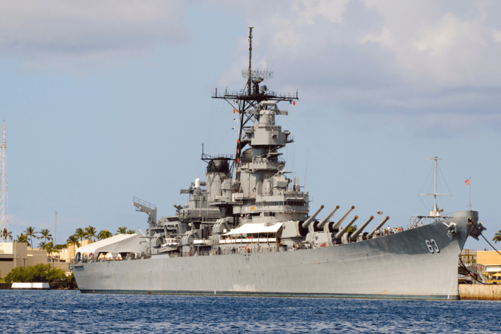 a large ship in a body of water with USS Missouri (BB-63) in the background