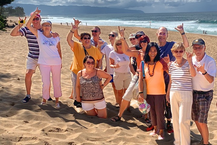 a group of people standing on top of a sandy beach
