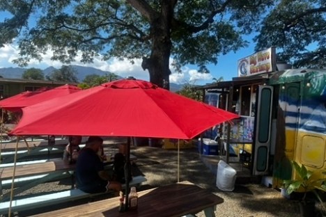 a group of people sitting at a table with an umbrella